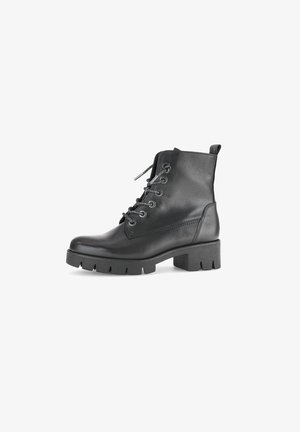 Bottine en cuir noir avec un bout arrondi, un laçage à l'avant et une semelle chunky et texturée. Comprend des coutures renforcées et une languette.