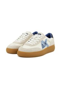 Sneakers bianchi e beige con una tomaia in suede texturizzato, dettagli blu, suola in gomma color caramello e lacci bianchi con un particolare logo blu.