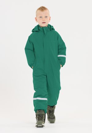 Grüner wasserdichter Overall mit Kapuze, elastischen Bündchen und reflektierenden weißen Streifen, kombiniert mit schwarzen und olivgrünen Stiefeln. Glatte Textur.