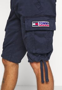 Námornické cargo šortky vyrobené z bavlny s tkaničkou na spodním lemu, které mají našitou logovou nášivku a několik kapes pro úložný prostor.