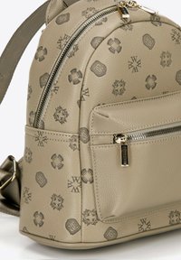 Zaino in pelle beige con motivo embossé, forma arrotondata, tasca frontale con zip e spallaccio regolabile. Accenti in hardware color oro.