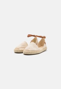 Beige espadrilles with floral embroidery, jute sole, and a brown ankle strap. Soft fabric and a rounded toe design.