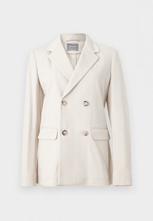 Kremfarvet dobbeltradet blazer med brede revers, fire knapper, klaplommer og tekstureret stof, vist på ensartet baggrund.