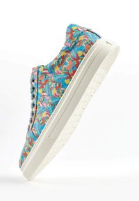 Colorful patterned sneaker with a blue, pink, and yellow design, smooth textile upper, and white rubber sole with a textured grip pattern.