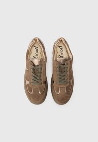 Brune semskede sneakers med grønne snørebånd. Har en glat bronze accent på tåen og sidepanelene, samt en struktureret gummisål.