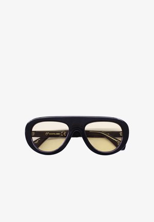 Occhiali da sole rettangolari con montatura spessa nera e lenti gialle sfumate, con una leggera curvatura nella parte inferiore delle lenti.