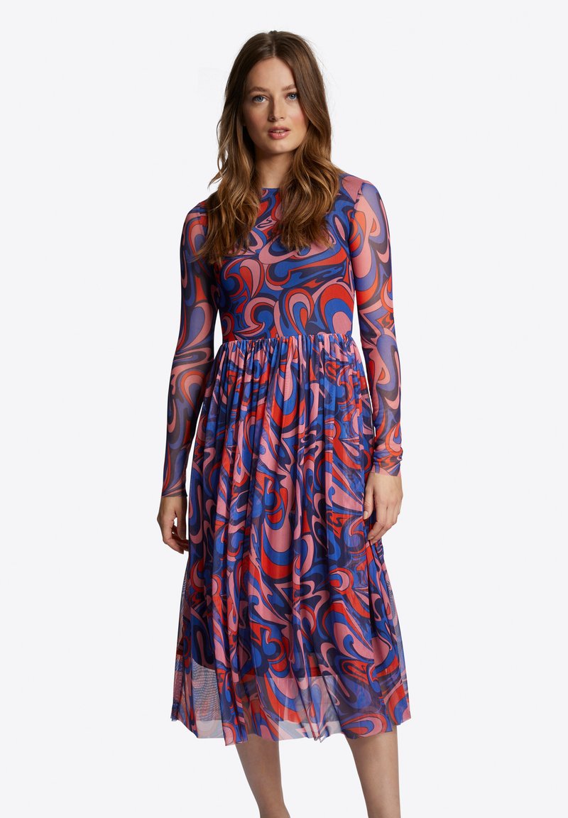 Long-sleeve dress with a vibrant swirling pattern in blues, pinks, and reds. Flowy, pleated skirt made of lightweight fabric.