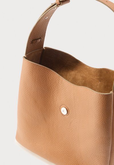 Τσάντα ώμου από δέρμα με υφή ταν, με φαρδιά λουρί και κλείσιμο με μαγνητικό κούμπωμα, ανοικτή για να αποκαλύψει το μαλακό εσωτερικό από σουέντ.