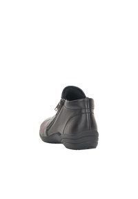 Botines de piel negra con cierre de cremallera en el lateral, tacón curvado y textura suave. Punta redondeada y detalles de costura sutiles.