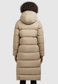 Beige Daunenjacke mit Kapuze, mit einem gesteppten Design, langer Länge und elastischen Bündchen. Sie hat eine glatte Textur und seitliche Reißverschlüsse.