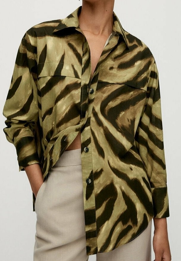 Button-up shirt in olive green and beige, featuring a bold tiger stripe pattern. Made of a smooth fabric with long sleeves and a collar.