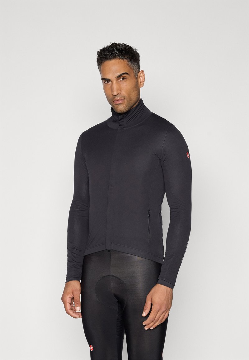 Maillot de cyclisme à manches longues en tissu noir avec col haut, coupe ajustée et poche zippée sur le côté. Texture lisse et design minimaliste.