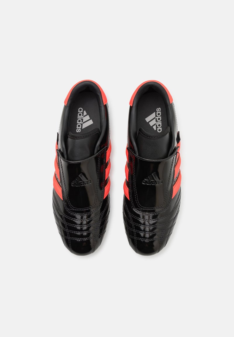 Zapatos de cuero negro con acabado brillante, con acentos rojos y tres rayas. Punta redondeada y plantillas acolchadas para mayor comodidad.