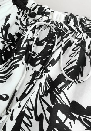 Kerge materjaliga joonistatud lühikesed püksid musta ja valge abstraktse mustriga, elastse vöökohaga ja sileda tekstuuriga.