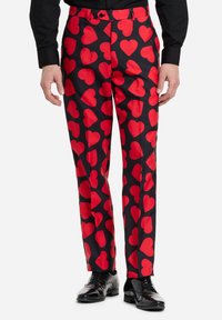 Mustad püksid läikiva viimistlusega, millel on korduv suurte punaste südamete muster. Kerekujundus koos vastava punase vöökoha ja nupuga.