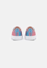 Růžové a modré plátěné slip-on tenisky s texturovaným povrchem, bílou gumovou podrážkou a kontrastním prošíváním na patě.