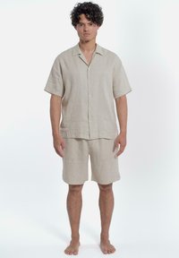 Linnen set bestaande uit een overhemd met korte mouwen en shorts in lichtbeige, met een knoopsluiting, een ontspannen pasvorm en simpele stiksels.