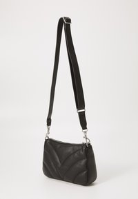 Borsa a spalla in pelle nera con design geometrico trapuntato, chiusura a zip e tracolla regolabile, con dettagli in metallo argentato.