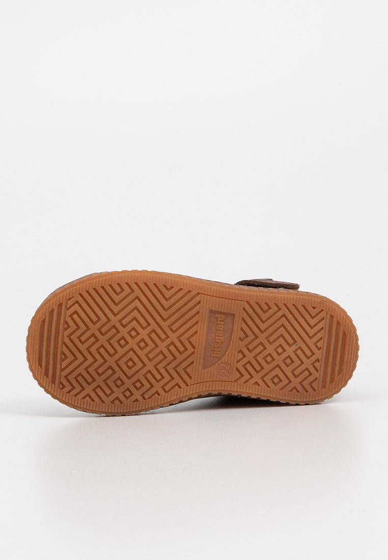 Sole in gomma marrone con un motivo testurizzato a zigzag e geometrico, con un logo rettangolare posizionato al centro.