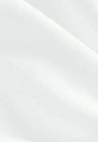 Tessuto bianco con una superficie liscia e leggermente strutturata, che mostra motivi sottili. Il materiale sembra leggero e flessibile.