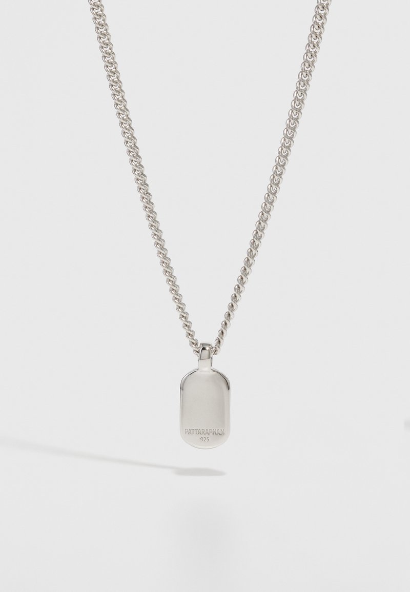 Strieborný náhrdelník s textúrovaným oválnym príveskom. Ťahokov sa vyznačuje skrúteným dizajnom, čo mu dodáva moderný vzhľad. Na prívesku je vygravírované meno značky.