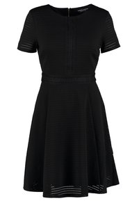 Svart kortärmad klänning med figurnära överkropp, utsvängd kjol och strukturerat mönster. Har en dragkedja bak och spetsliknande detaljer vid midjan.