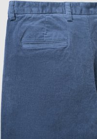 Blaue Cordhosen mit vertikal geriffelter Textur, einer Gesäßtasche und einem flexiblen Bund für Komfort.