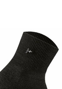 Sort ribbet ankelstrømpe lavet af blødt materiale, med et lille logomærke på kanten, med en glat overflade og tætsiddende pasform.