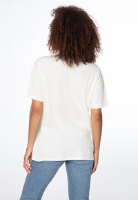 Crème-kleurig katoenen t-shirt met een relaxed fit en korte mouwen, voorzien van een ronde halslijn en gestikte zoom. Soepele textuur.
