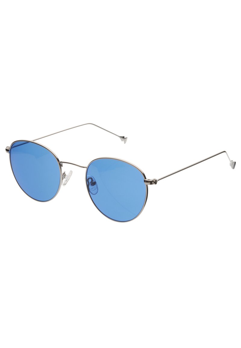 Gafas de sol con tinte azul, con un delgado marco de metal plateado, lentes ovalados y almohadillas nasales ajustables. Diseño minimalista con patillas finas.