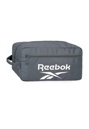 Bolsa de aseo rectangular de color gris oscuro de Reebok con bolsillo delantero con cremallera y asa lateral, con el logo blanco de Reebok en el panel frontal.