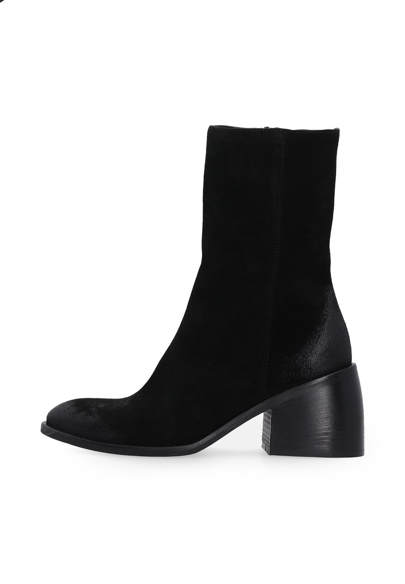 Schwarze Wildleder-Stiefelette mit runder Spitze, kurzem Schaft und einem leicht strukturierten Blockabsatz. Die glatte Oberfläche des Absatzes steht im Kontrast zum Obermaterial.