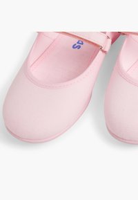 Scarpe da balletto in tela rosa con punta tonda, cinturino elastico e superficie testurizzata. L'interno è liscio, con una piccola etichetta della taglia visibile.