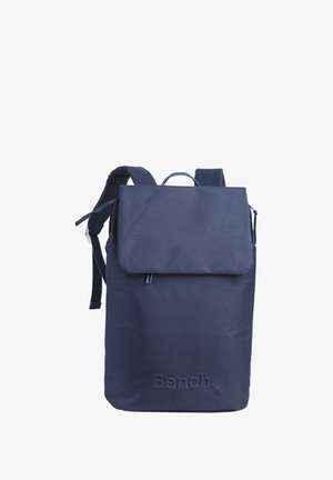 Marineblauwe stoffen rugzak met een klep sluiting, verstelbare schouderbanden en een handvat aan de bovenkant. Voorzien van een reliëflogo aan de voorkant. Gladde textuur.