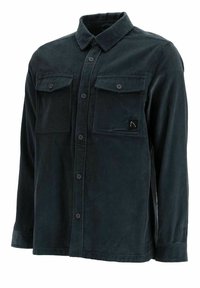 Dark green corduroy shirt featuring a button-down front, two chest pockets, and a black logo patch. Textured fabric with visible stripes.