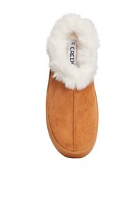 Zapatilla de ante marrón con un cuello de piel sintética blanca. Diseño de punta cerrada con una textura suave y suela ligera marrón. Etiqueta de tamaño visible en el interior.