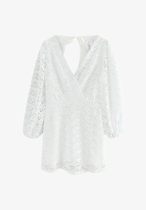 Hvid blondekjole med V-hals, pufærmer og scallop kant. Det indviklede blondemønster inkluderer blomsterdesigns.