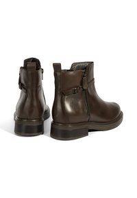 Bottines en cuir marron avec un bout rond, fermeture éclair sur le côté et détail de boucle. Caractéristiques : semelle basse et texturée pour plus de stabilité.
