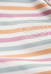 Flerfärgad randig tyg med ljusblått, orange, rosa och vitt. Inkluderar en cirkulär logotyp prägling i vitt.