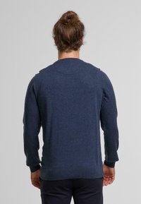 Maglione a maglia blu navy con maniche lunghe, scollo rotondo, polsini e orlo a coste. Texture morbida, vestibilità casual e dettagli minimi.