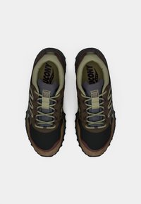 Běžecké boty do terénu s černým a hnědým svrškem, se strukturovanou podrážkou, šedými akcenty a zesílenou špičkou. Šněrovací design.