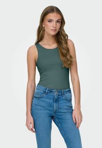 Top a maniche corte di un verde scuro e rigato con scollatura rotonda abbinato a jeans in denim blu a vita alta. Presenta un design aderente e una texture liscia.