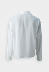 White long-sleeve shirt with a collared neckline and smooth, slightly glossy texture. Features a relaxed fit and curved hemline.