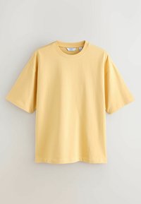 T-shirt en coton jaune oversized à manches courtes avec col rond, présenté sur un fond clair uni.