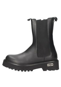 Bottines noires avec une finition en cuir lisse, des panneaux latéraux élastiques et une semelle extérieure épaisse et texturée. Détails de logo sur le talon.