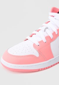 Różowo-biały sneaker z cholewką ze skóry, perforowanym noskiem, białymi sznurowadłami i teksturowaną gumową podeszwą. Posiada kontrastujące akcenty w kolorze różowym.