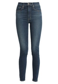 Jeans ajustados de color azul oscuro, hechos de denim, con cintura alta, dos bolsillos frontales y cremallera con cierre de botón.