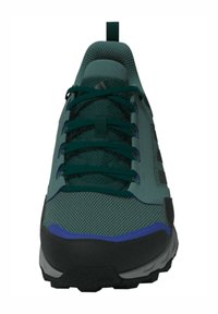 Grüner Sportschuh mit Obermaterial aus Mesh, dunklen Akzenten und kontrastierenden lila Details. Verfügt über einen gepolsterten Kragen und eine robuste Sohle mit Traktionsmuster.