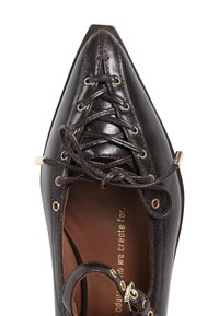 Zapato de cuero marrón con punta afilada, detalles de cordones y ojales de tono dorado. Textura suave con un brillo sutil en la parte superior.