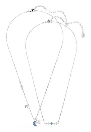 Dos delicados collares de plata: uno con un colgante de media luna azul y estrella, y otro con detalles en forma de estrella en azul y plata.